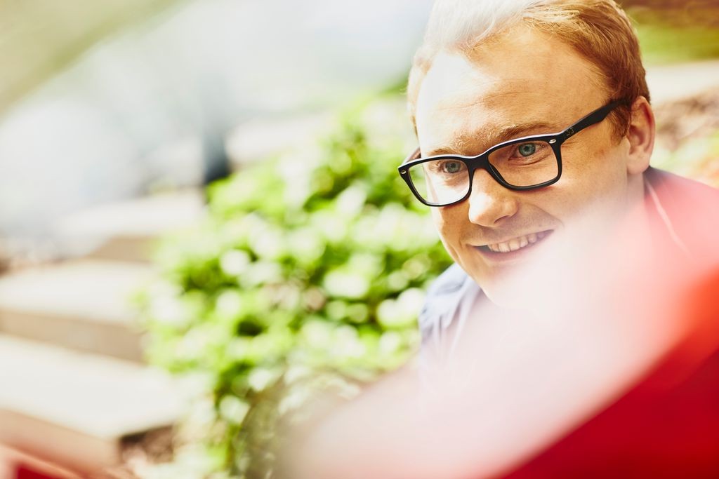 student_glasses_smiling_green_shrubs_453