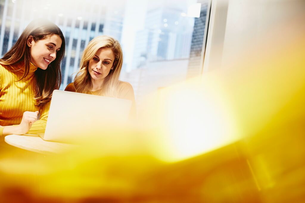 Zwei Frauen arbeiten am Laptop zusammen