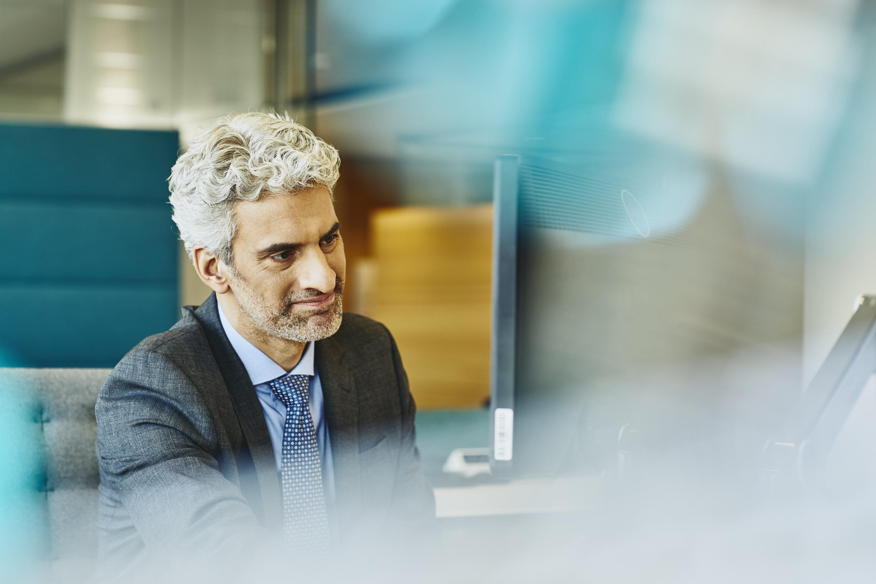 Älterer Mann arbeitet am Schreibtisch