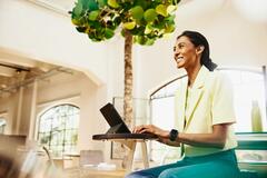 Smiling woman sitting at table working on a tablet_1265