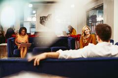 Zwei Frauen und ein Mann in einer Sitzgruppe