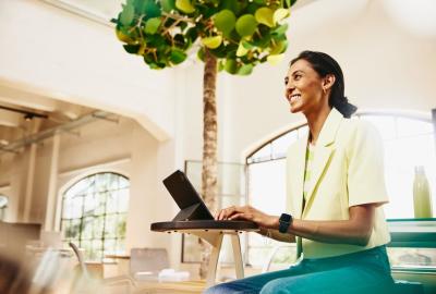 Smiling woman sitting at table working on a tablet_1265