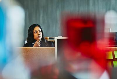 Frau sitzt nachdenklich am Schreibtisch