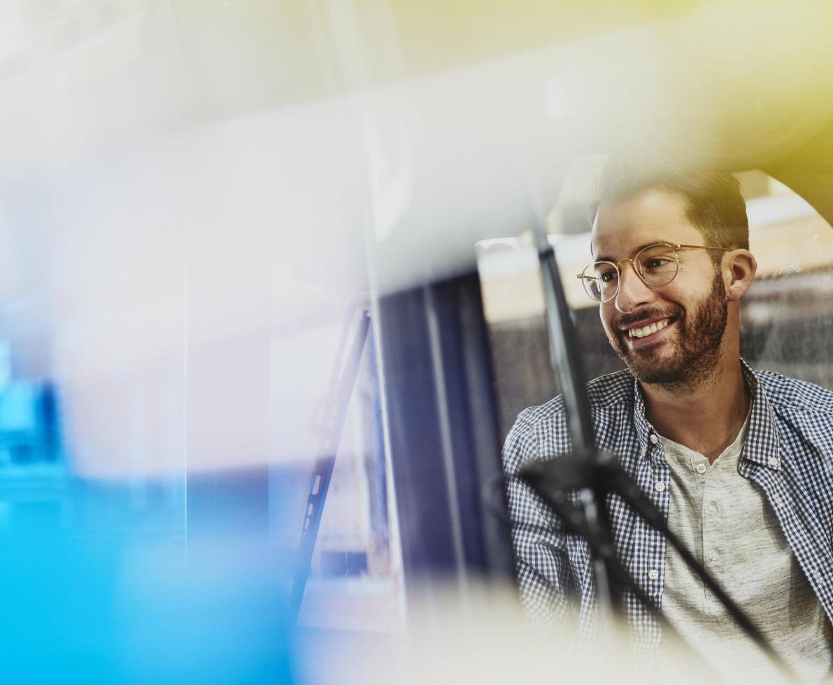 Male caucasian worker operating a forklift in a logistics environment. Blue-collar. Smiling.  Wearing glasses. Groomed beard and moustache. Checkered shirt. Primary color white. Secondary colors turqoise and yellow.