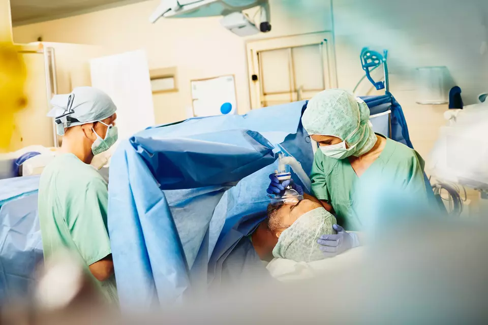  Ärzte in einem Operationssaal mit einem Patienten