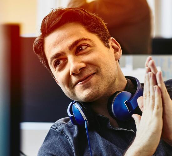 Mann mit Kopfhörern im Büro